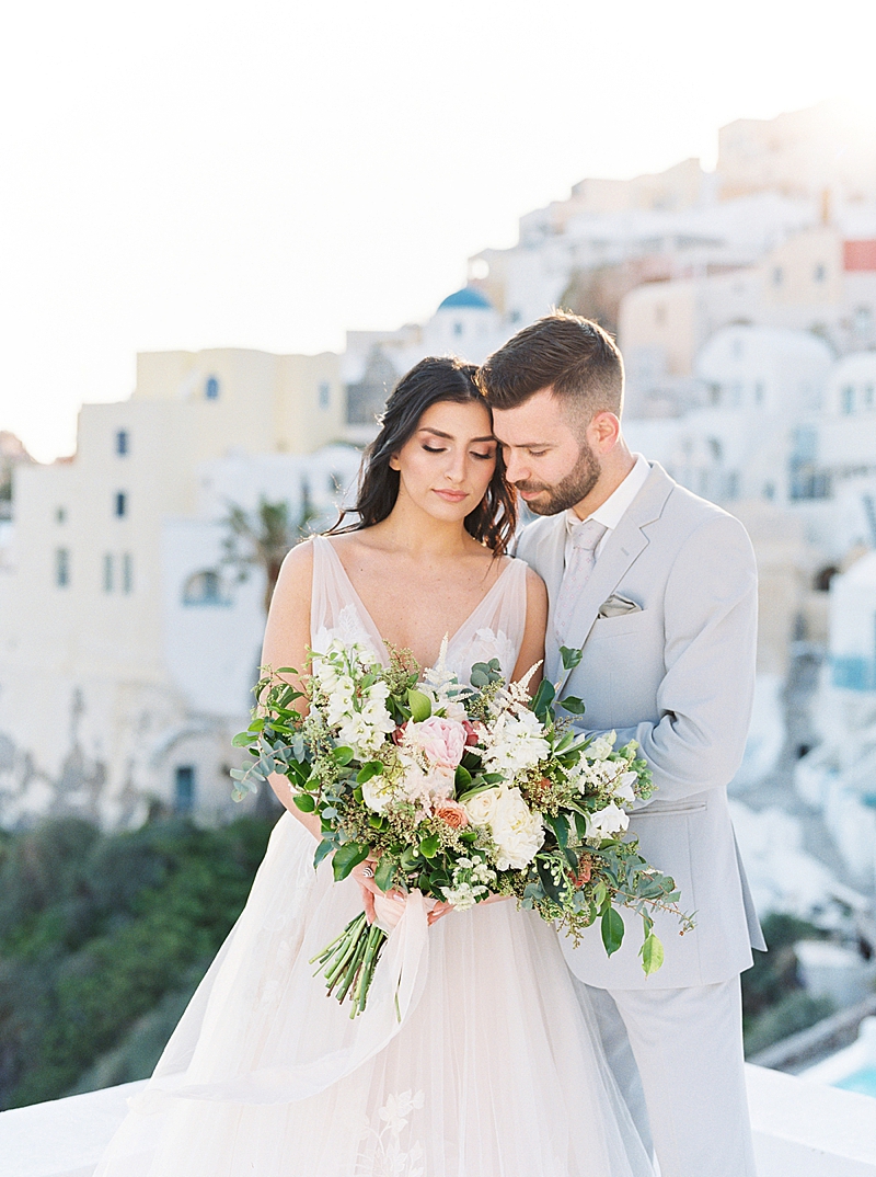 Oia Santorini Greece Destination Wedding Island Elopement, Film Photography, bride and groom with pink and white flowers wedding bouquet