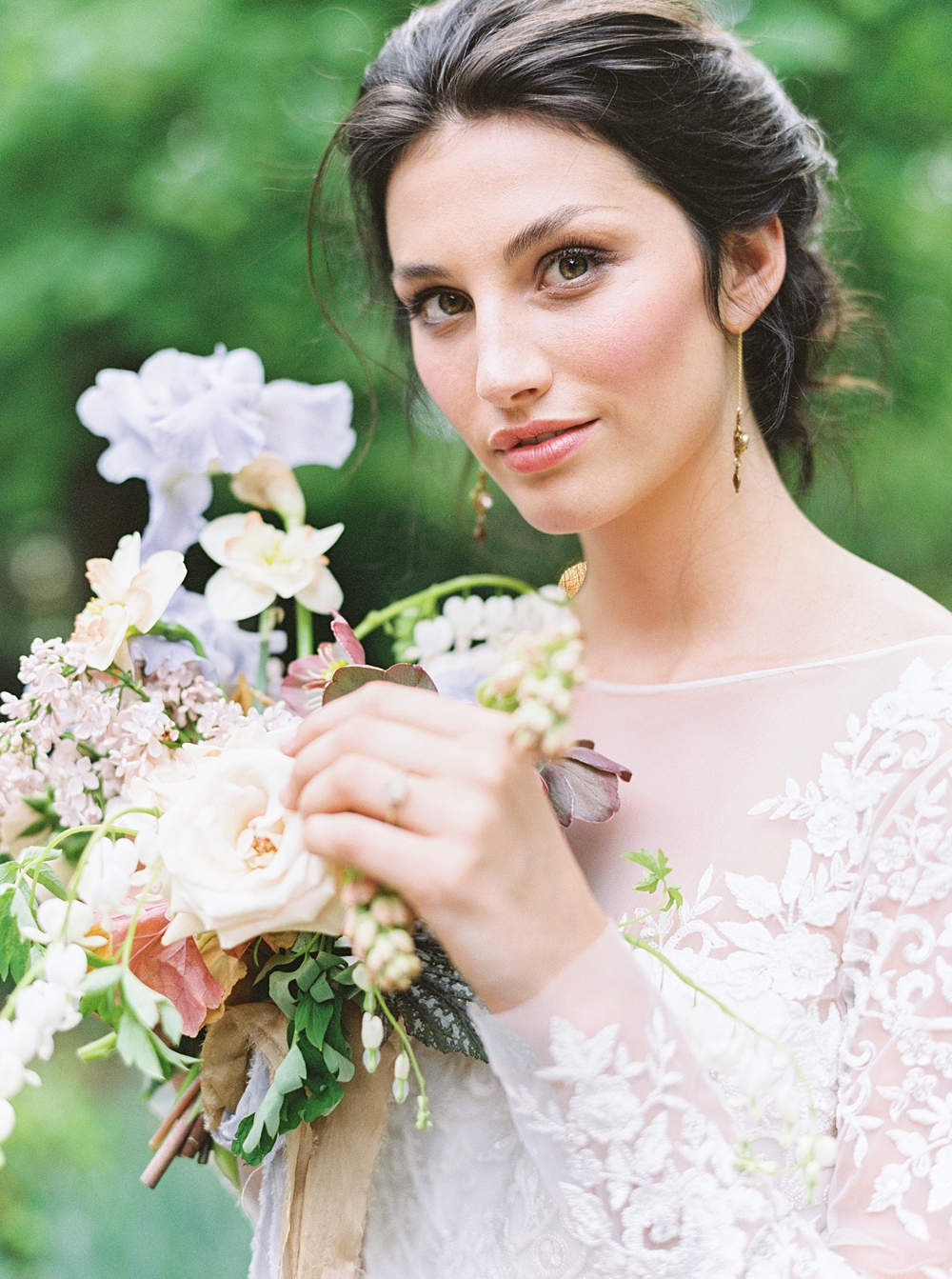 bride in long sleeve lace wedding dress with spring wedding bouquet, purple iris yellow daffodil colorful bridal bouquet