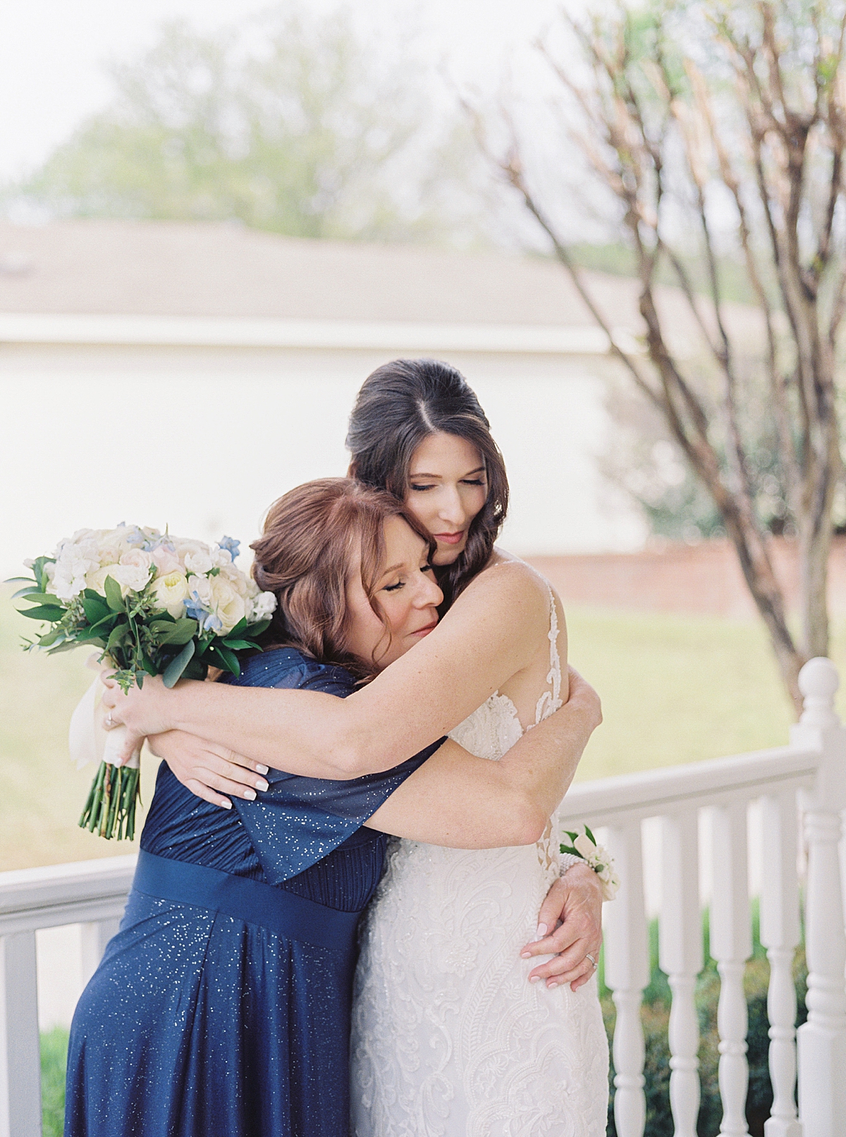 Mom and bride hug before wedding ceremony, navy mother-of-the-bride dress, white bridal bouquet, getting ready wedding photos, Virginia wedding photographer