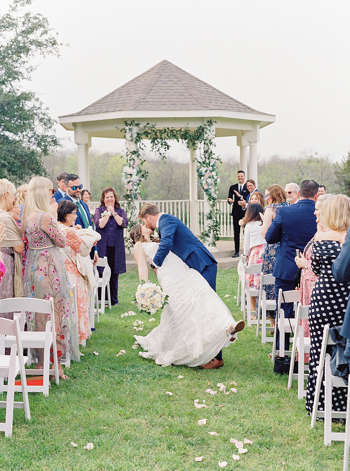Bride and groom kiss walking down the aisle in southern wedding at Milestone Mansion