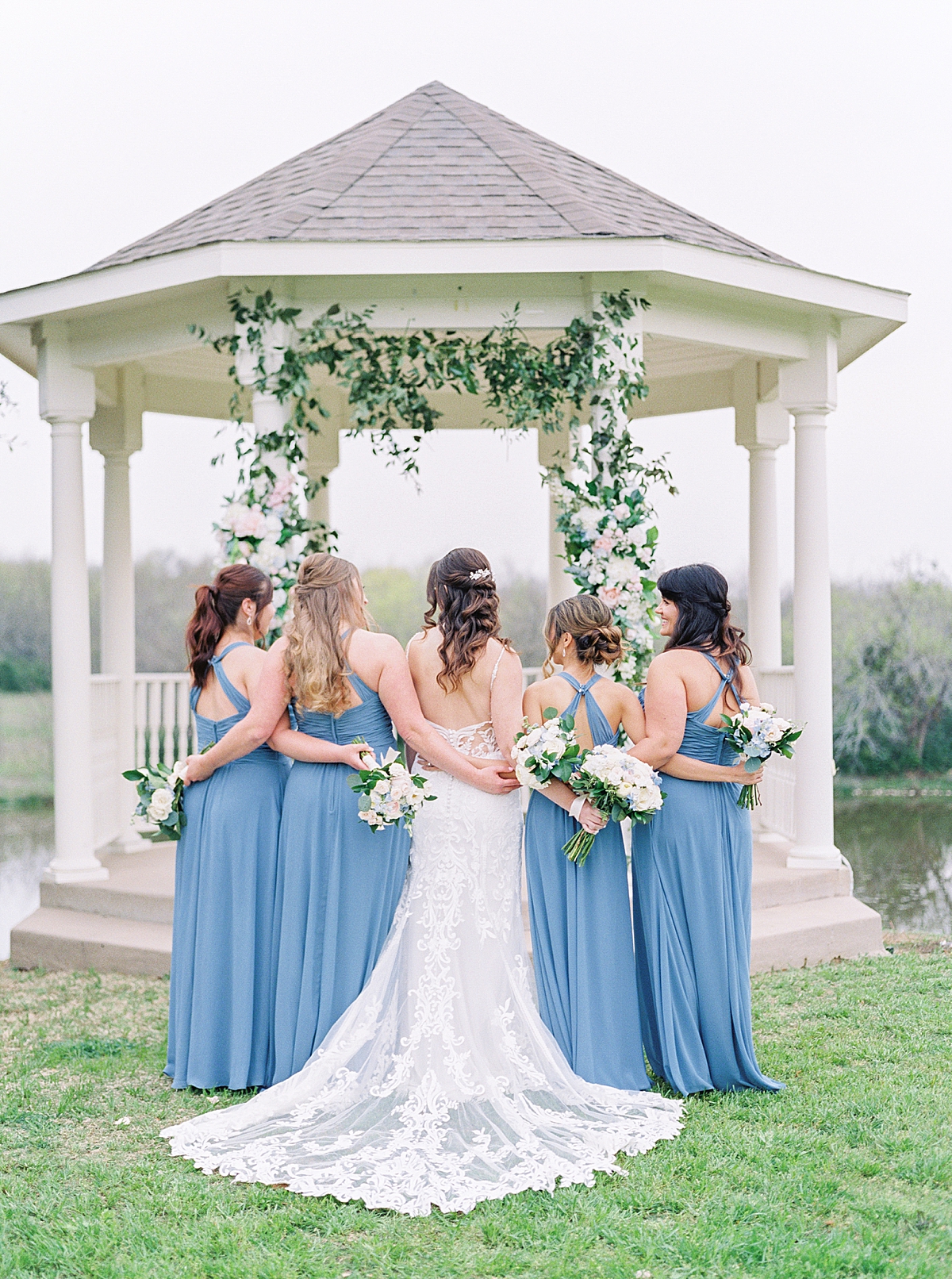 Bride and bridesmaids in front of gazebo, Southern mansion wedding, blue bridesmaid dresses