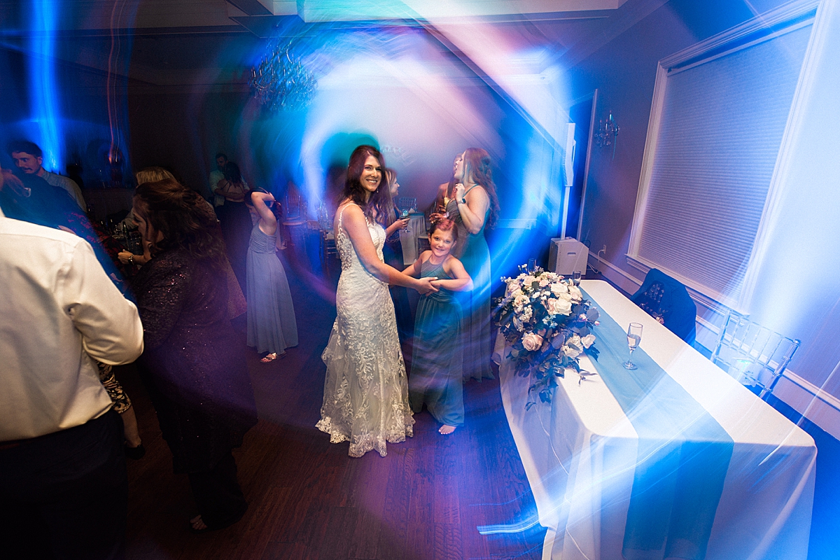 Bride dances at wedding reception with lights from DJ, wedding dancing